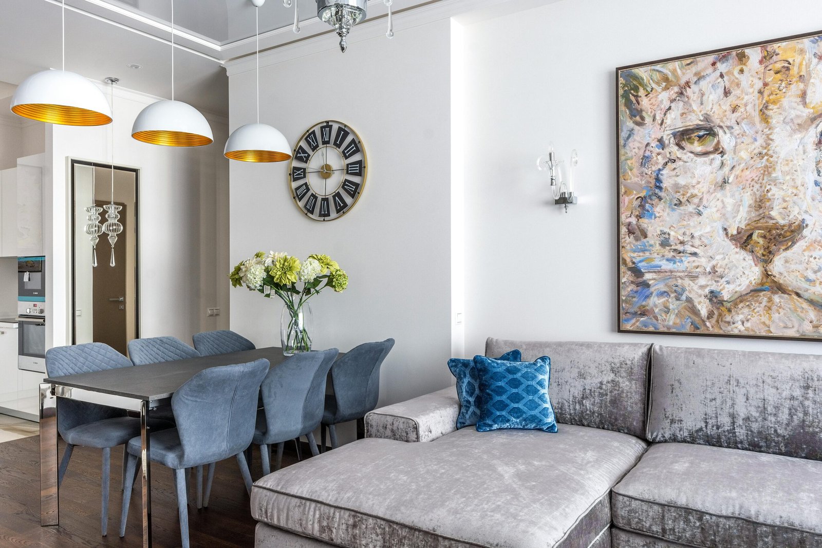 Stylish living room with contemporary furniture, lion painting, and a sleek dining area.
